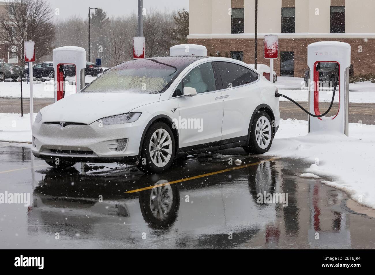 Tesla Model X an der Supercharging Station in der kleinen Stadt Big Rapids, Michigan, während eines verschneiten Winters, USA [Keine Eigentumsfreigabe; für EDIto verfügbar Stockfoto