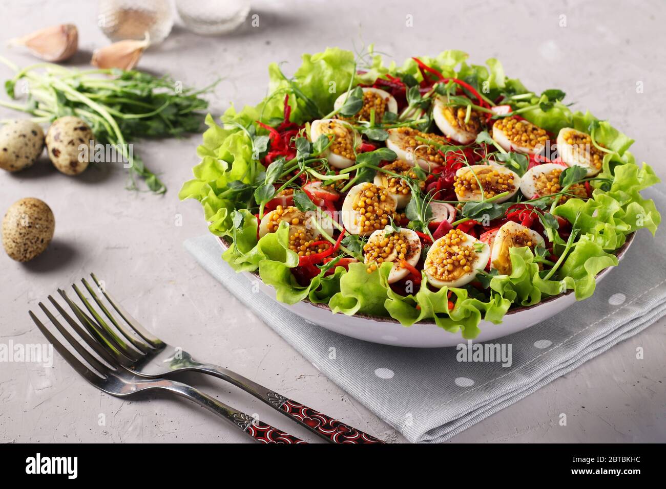 Salat aus Bio-Salatblättern, Erbsen, Mikrogrün, Karotten und Wachteleiern, gewürzt mit Senf und Olivenöl, Horizontal Format Stockfoto
