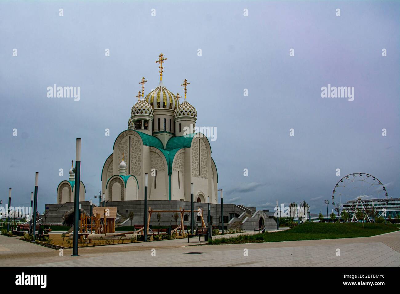 Orthodoxe Kirche mit Kreuzen und Kuppeln in einem Park mit grünen Bäumen. Blauer Himmel. Platz für Text kopieren. Pawschinskaja-Aue, Russland Stockfoto