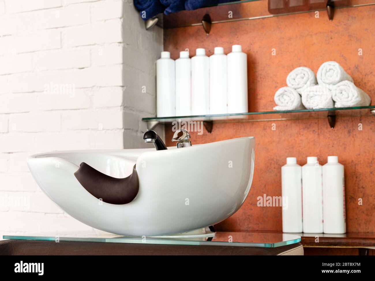Friseurschüssel im Schönheitssalon Interieur. Waschbecken zum Waschen der Haare, Haarpflege Spa-Verfahren in Friseur, Shampoos, Handtücher. Friseur-Stylistin Stockfoto