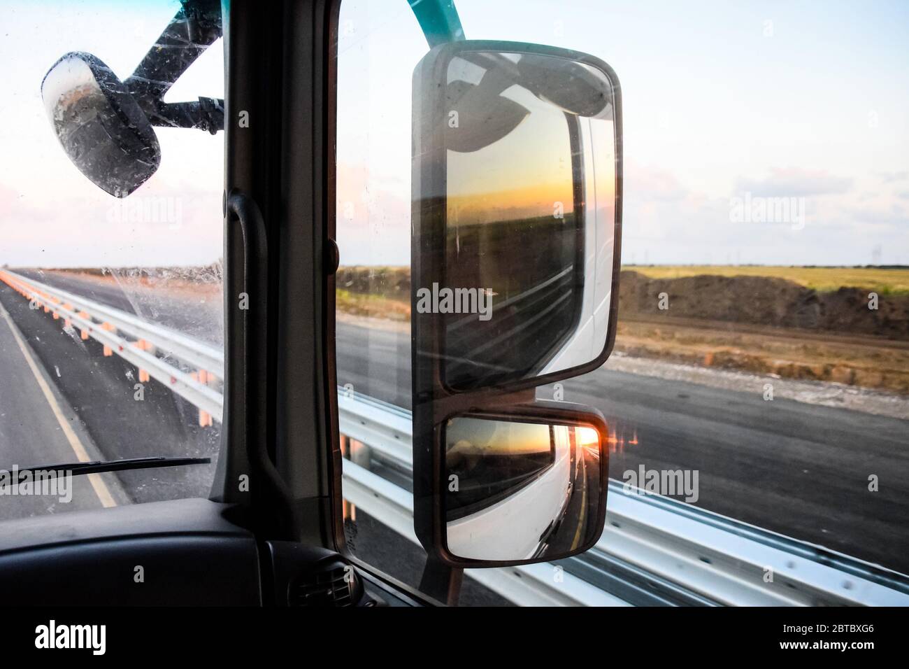 Im Cockpit eines LKWs bei Sonnenaufgang. Große Rückspiegel Stockfoto