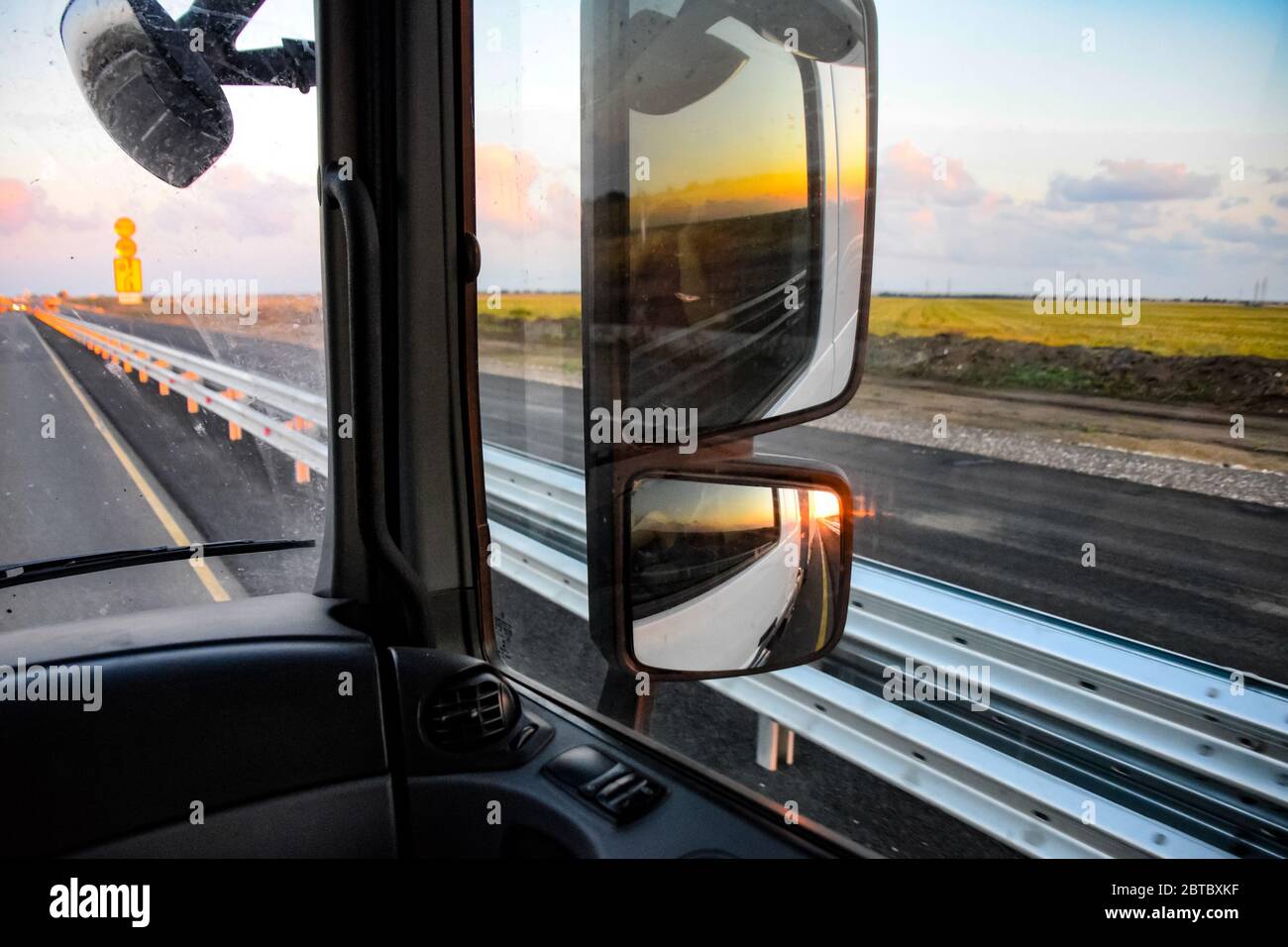 Im Cockpit eines LKWs bei Sonnenaufgang. Große Rückspiegel Stockfoto