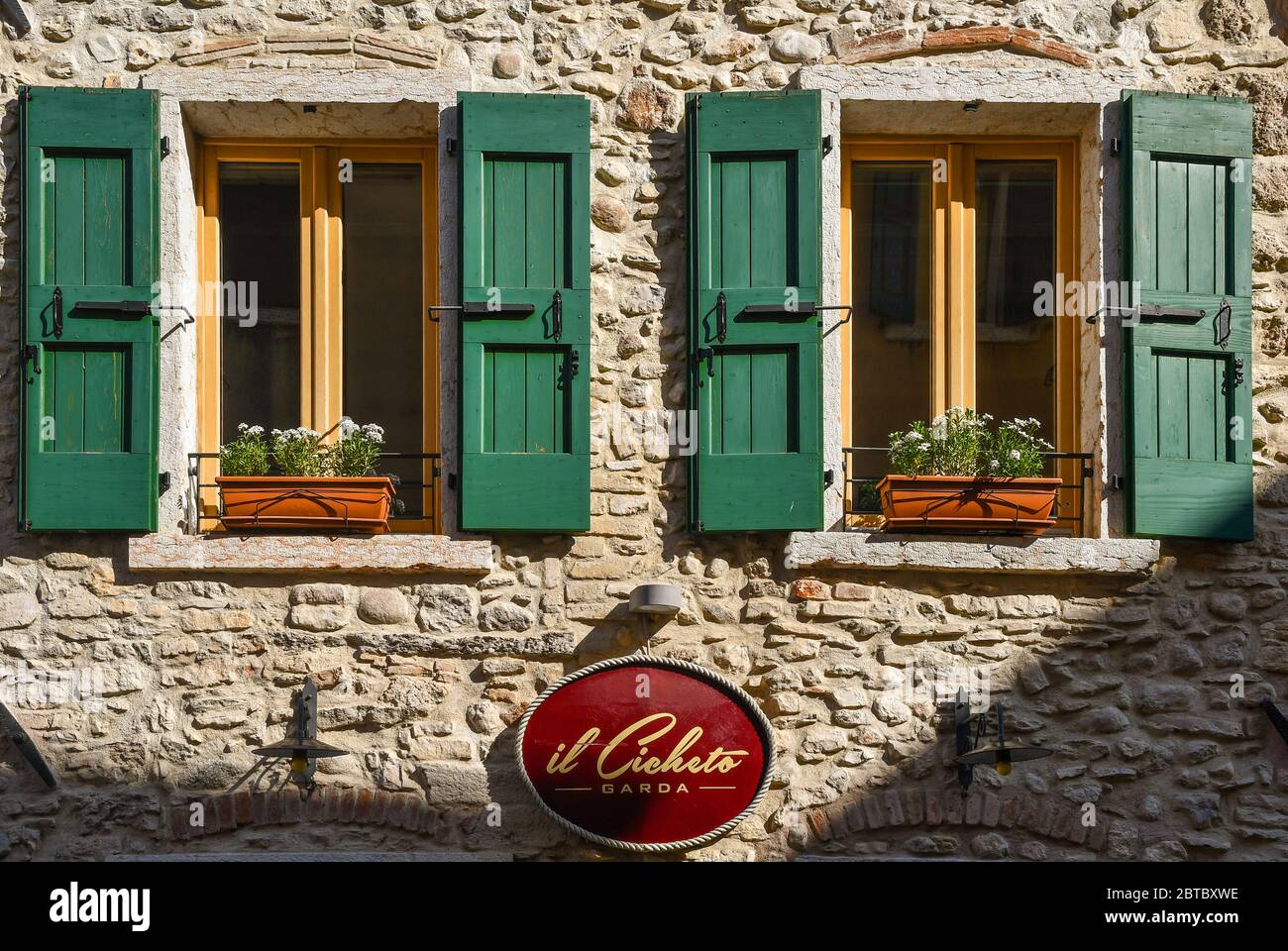 Nahaufnahme der steinernen façade der Taverne "Il cicheto", Name der leckeren Vorspeise der venezianischen Küche, mit zwei Fenstern, Garda, Venetien, Italien Stockfoto