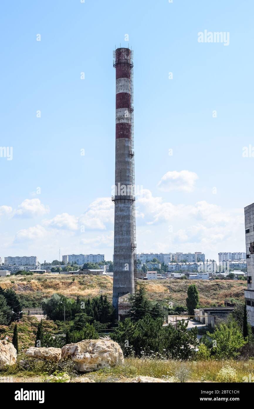 Eine alte sowjetische Fabrik mit einer Pfeife. Verlassene sowjetische Industrie. Stockfoto