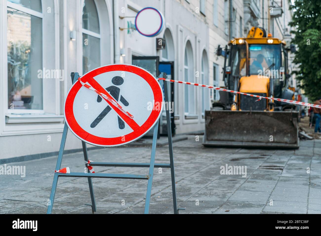 Warnschild kein Eintrag im Hintergrund der Straßenarbeiten in der Stadt mit gelben Bulldozer. Stockfoto