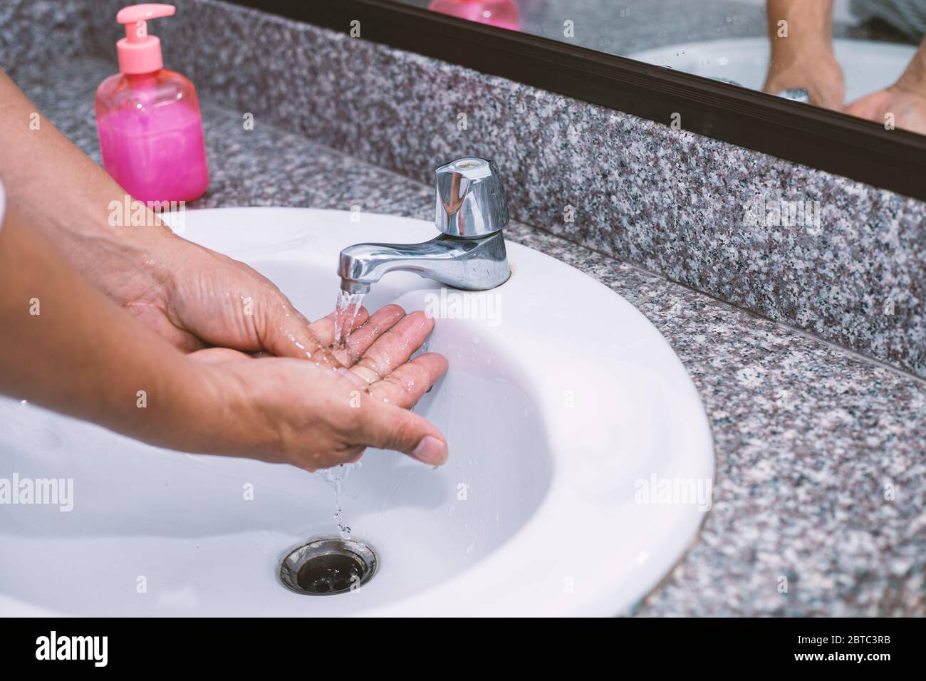 Die Hand eines Mannes wäscht und reinigt die Hände Stockfoto