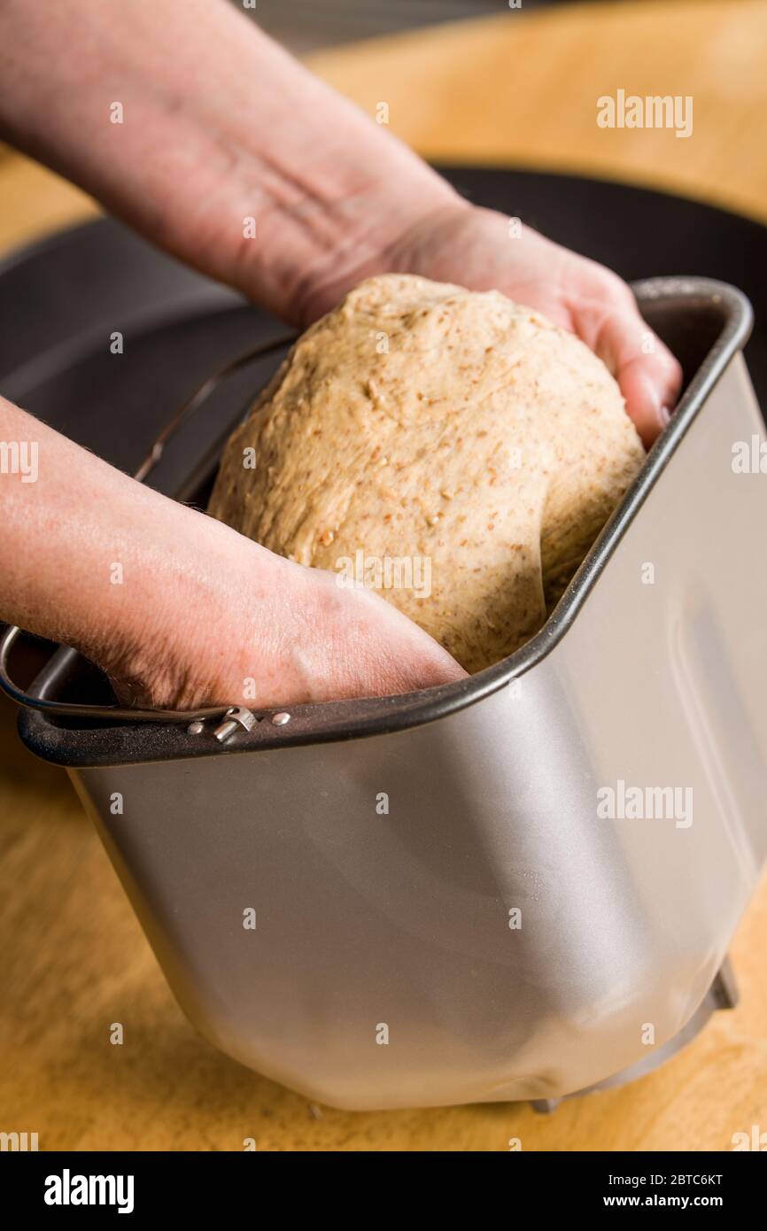 Die Zutaten für den Mehrkornteig mischen und – in diesem Fall mit der Hand, dem Mixer oder der Brotmaschine – zu einer glatten Kruste kneten. Stockfoto