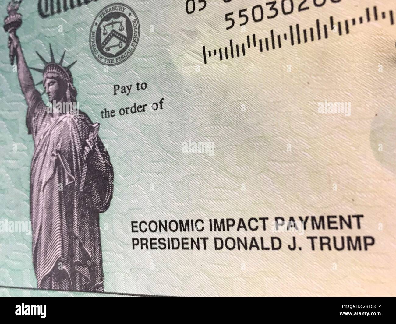 Nahaufnahme eines US-Schatzchecks, der US-Bürgern während der COVID-19-Krise finanzielle Unterstützung von Präsident Trump gewährt. Stockfoto