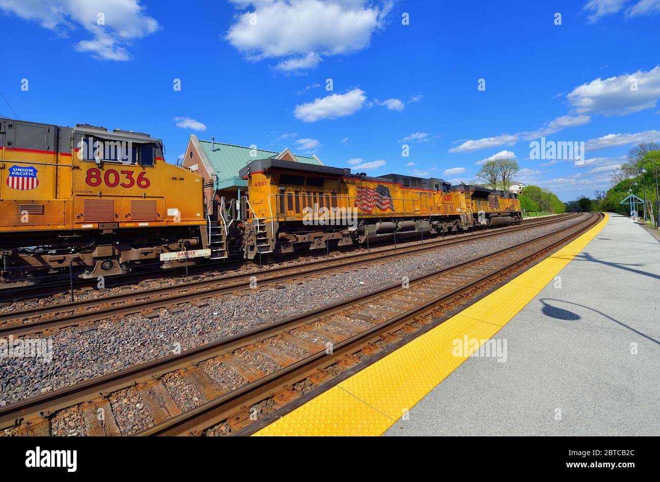 Winfield, Illinois, USA. Drei Lokomotiven führen eine Union Pacific-Fracht durch eine Pendlerstation in der Vorstadt Chicago. Stockfoto