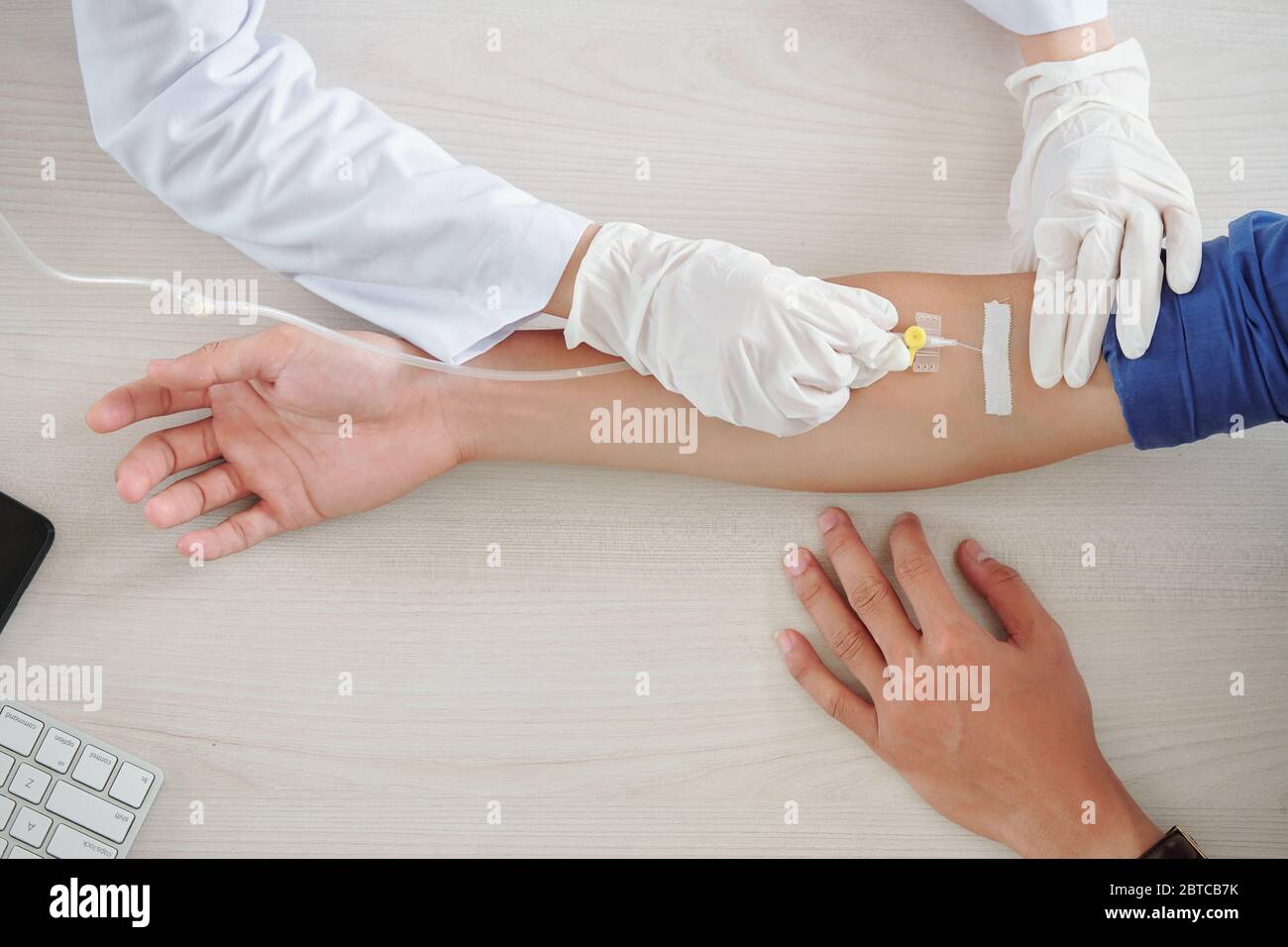 Patient mit Infusionstherapie im Krankenhaus, Krankenschwester mit Venenkatheter in Armvene Stockfoto