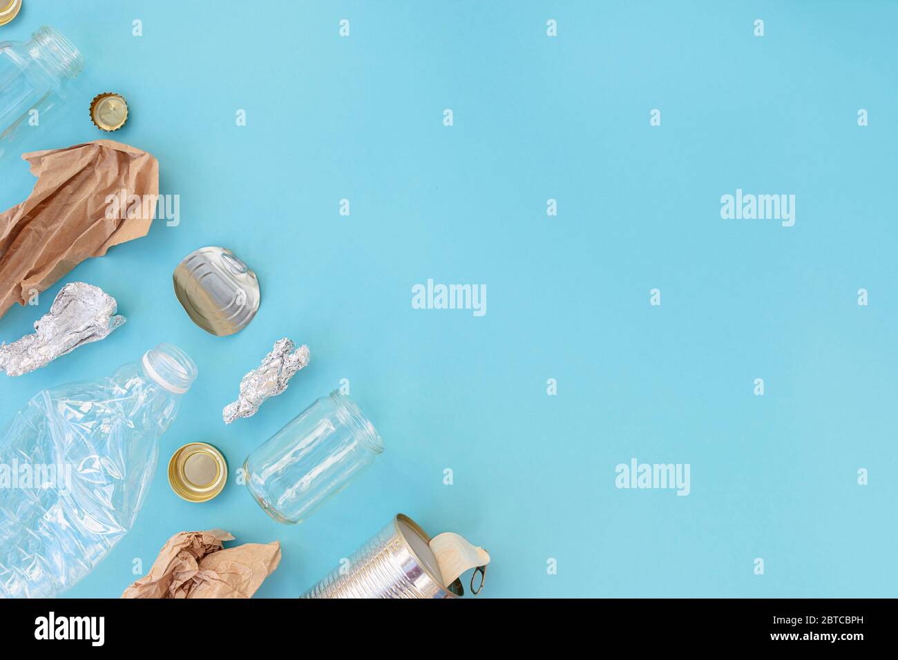 Recycelbarer verschiedener Müll bestehend aus Papier, Glas, Metall, Kunststoff auf blauem Hintergrund. Abfalltrennungskonzept. Flatlay, Kopierplatz. Stockfoto