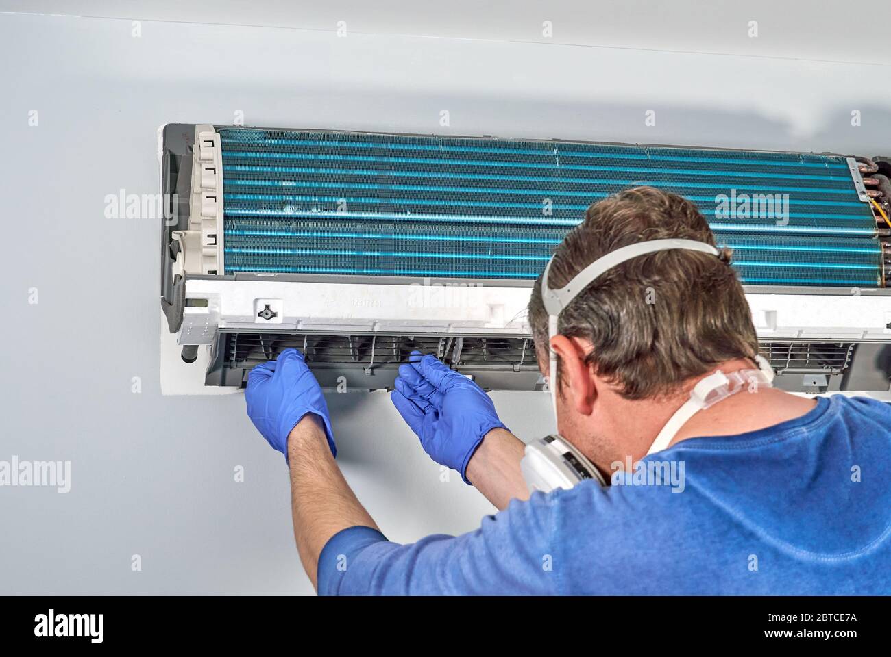 Techniker in blauen Handschuhen und Maske, die Klimaanlage demontieren und  für die Reinigung vorbereiten. Reinigung Klimaanlagen helfen, um Schimmel w  zu vermeiden Stockfotografie - Alamy