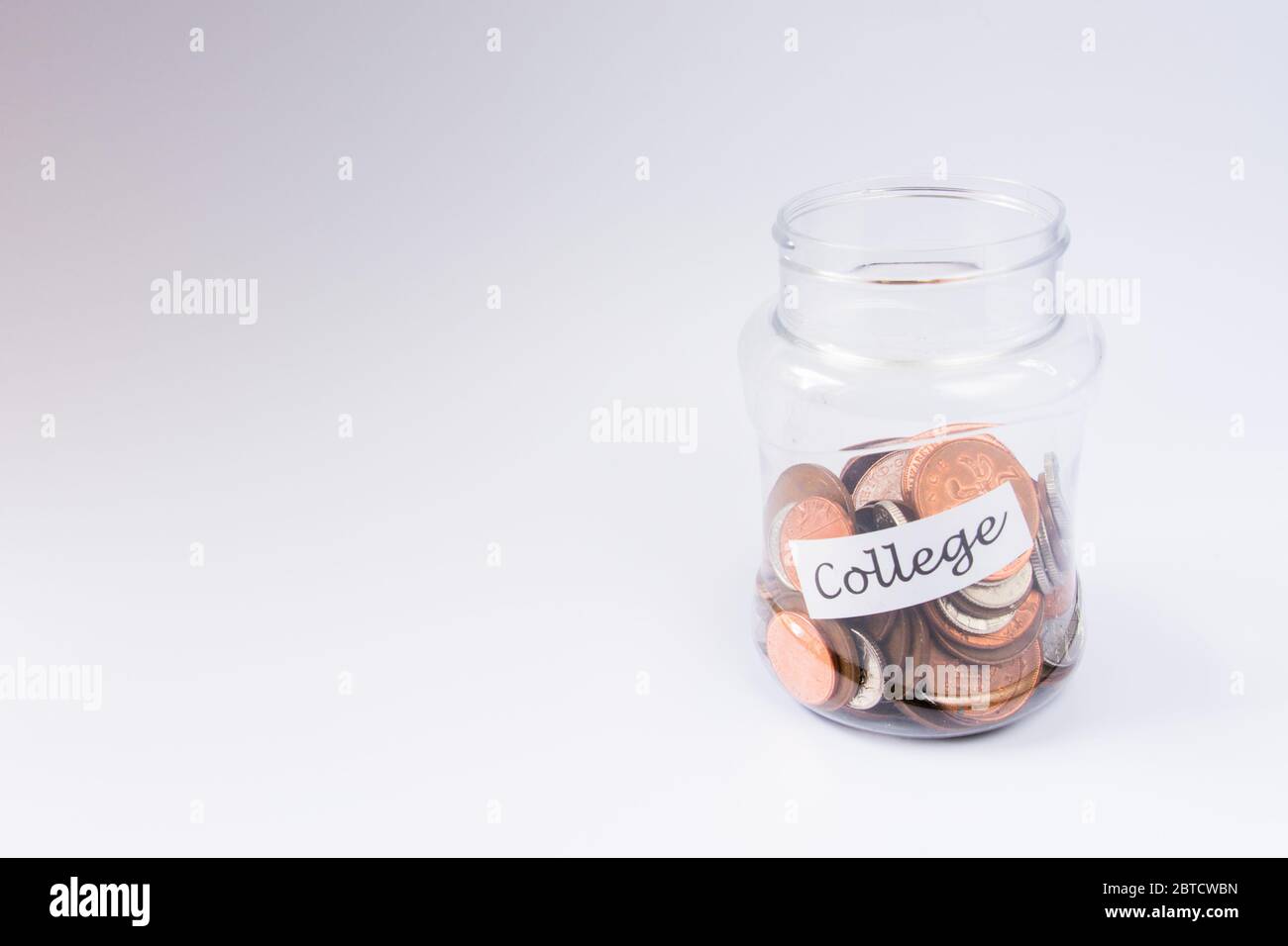 College Bildung Einsparungen Pennies in einem transparenten Glas mit Kopierraum Stockfoto