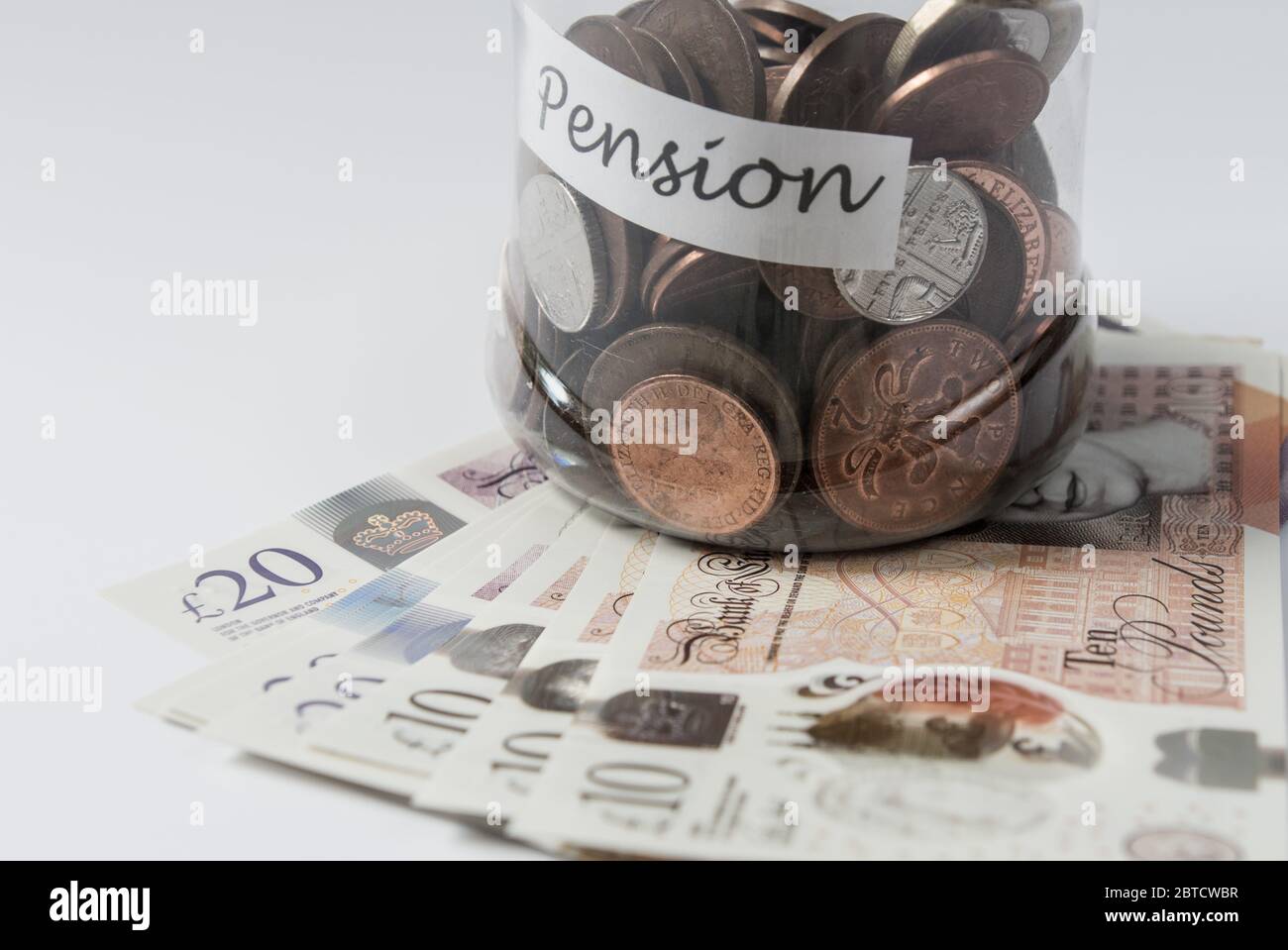 Geld- und Münzeinsparung im Glas als Spardose in Richtung Pension Stockfoto