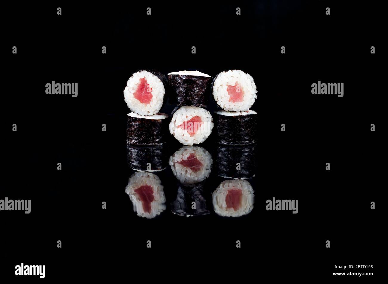 Leckeres Maki Sushi mit Thunfisch auf schwarzem Hintergrund. Asiatische Restaurantkarte. Vorlage Mockup, Platz für Text. Stockfoto