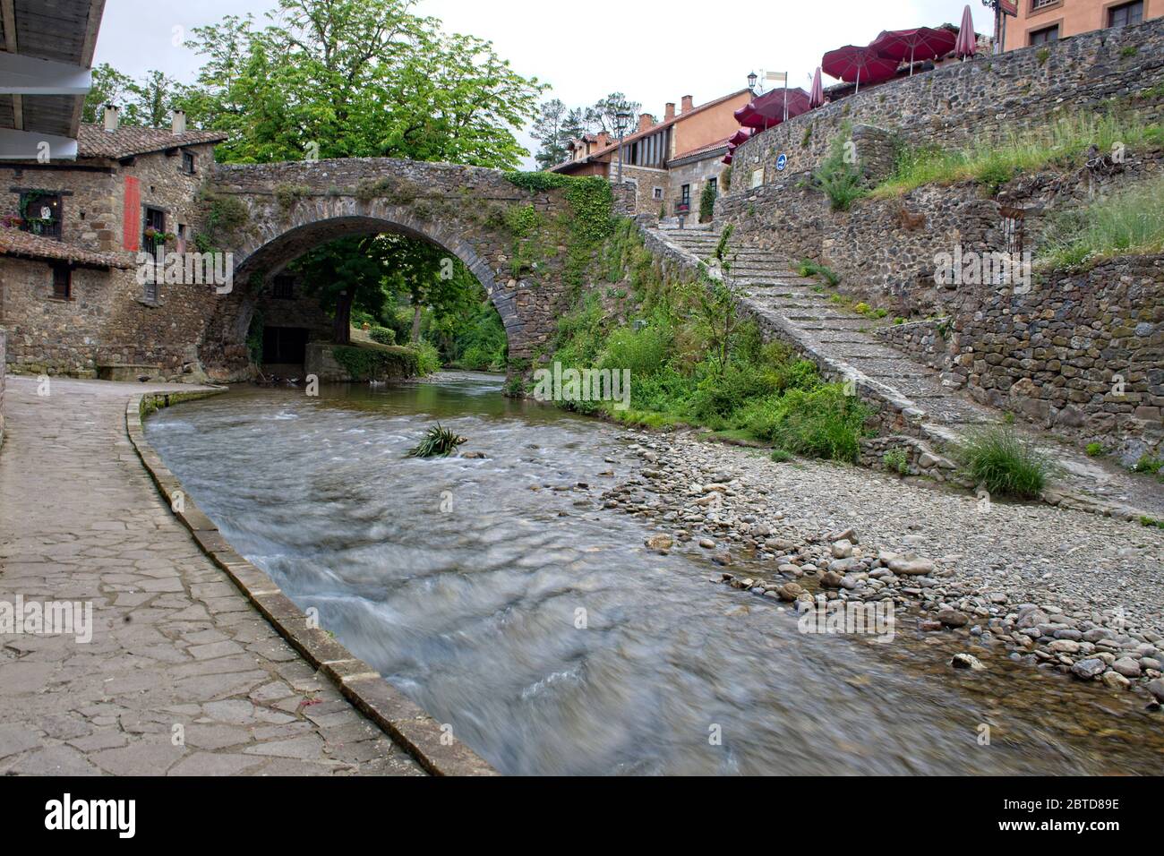 Der Fluss Quiviesa fließt unter einer alten Steinbrücke in Potes, Kantabrien, Spanien. Stockfoto
