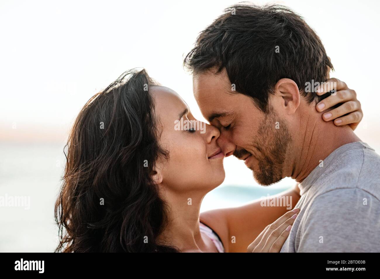 Liebevolles Paar mit geschlossenen Augen am Strand Stockfoto