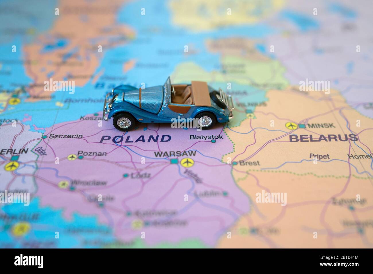 Kleines Spielzeug Retro Auto auf Europa Karte in Polen. Anreise mit dem Auto Konzept. Stockfoto