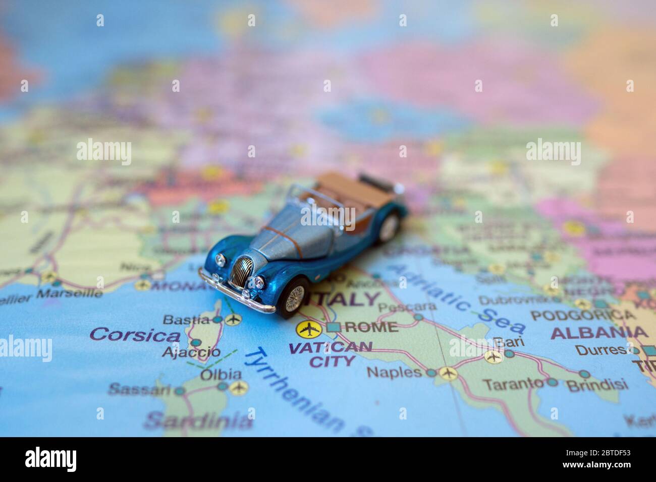 Kleines Spielzeug Retro Auto auf Europa Karte in Italien. Anreise mit dem Auto Konzept. Stockfoto