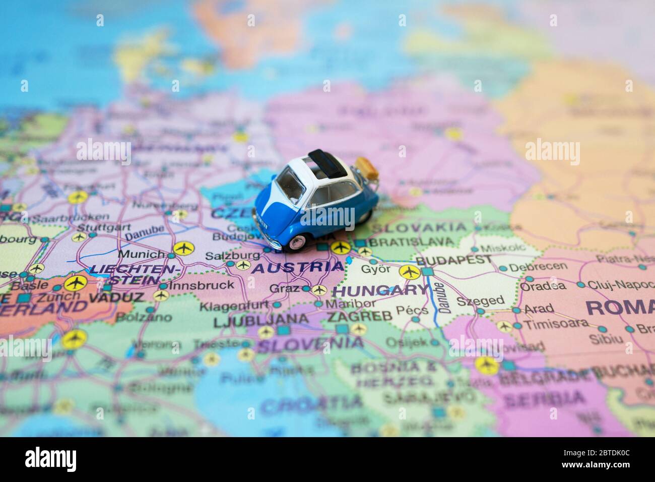 Kleines Spielzeug Retro Auto auf Europa Karte in Österreich. Anreise mit dem Auto Konzept. Stockfoto