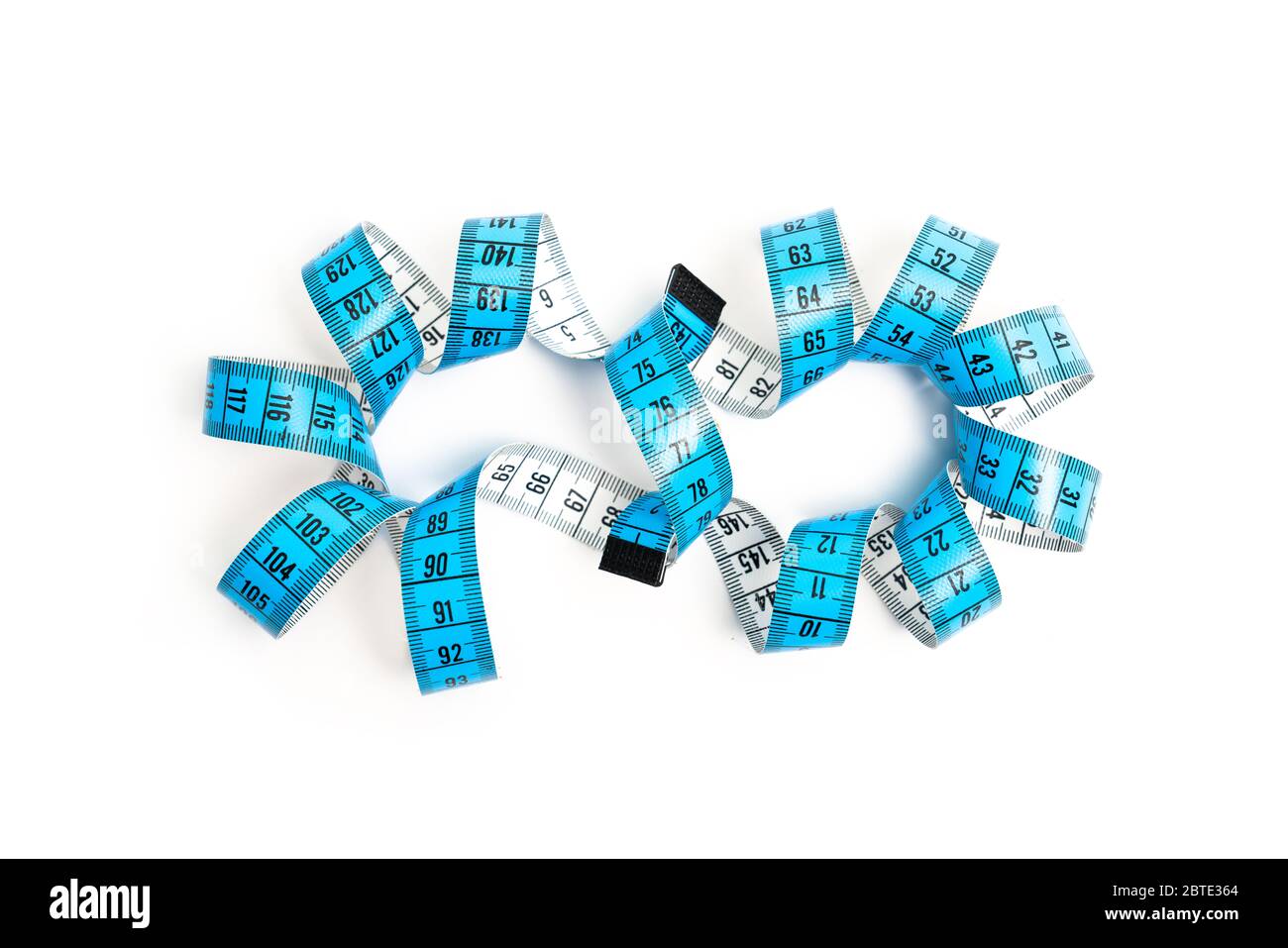 Ein Objekt über Nähmessband mit Ewigkeitsform auf isoliertem weißem Hintergrund. Näh- und Schneidekonzept Stockfoto