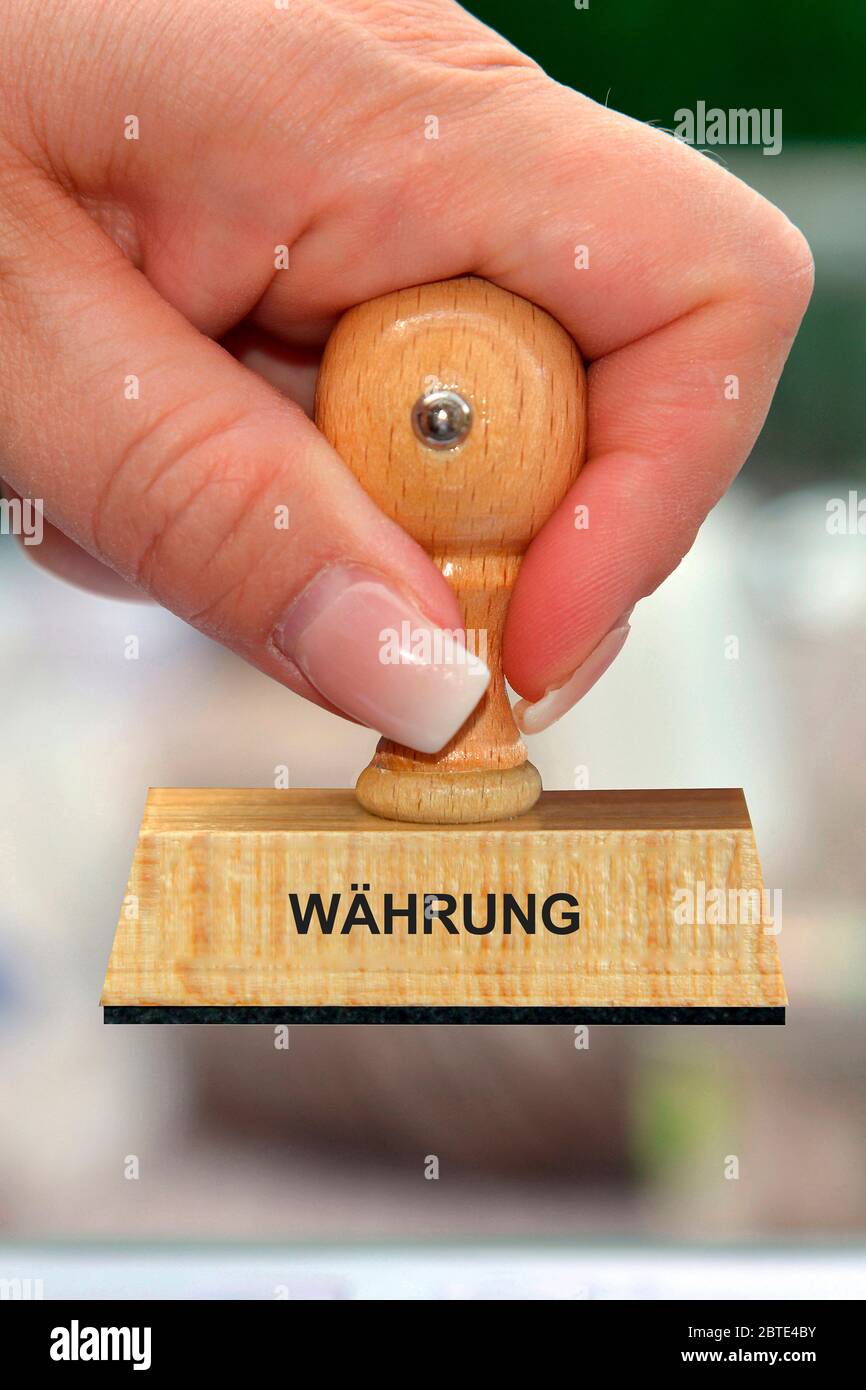 Hand mit Holzstempel bedruckt mit Waehrung Stockfoto