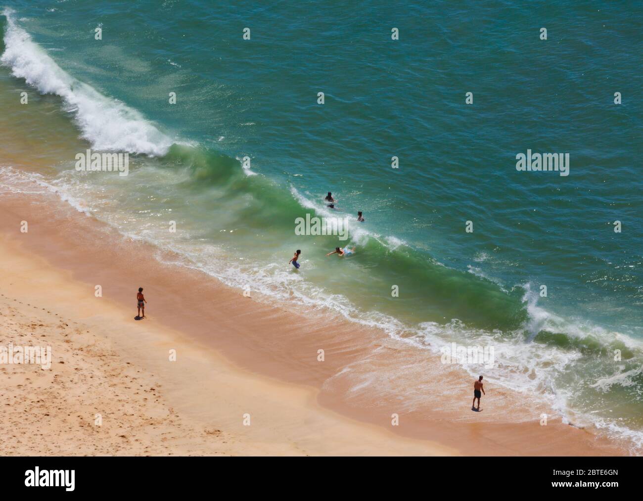 Nazare, Provinz Leiria, Portugal. Raue See. Große Wellen, die auf das Ufer schlagen. Schwimmer versuchen, Körper surfen. Stockfoto