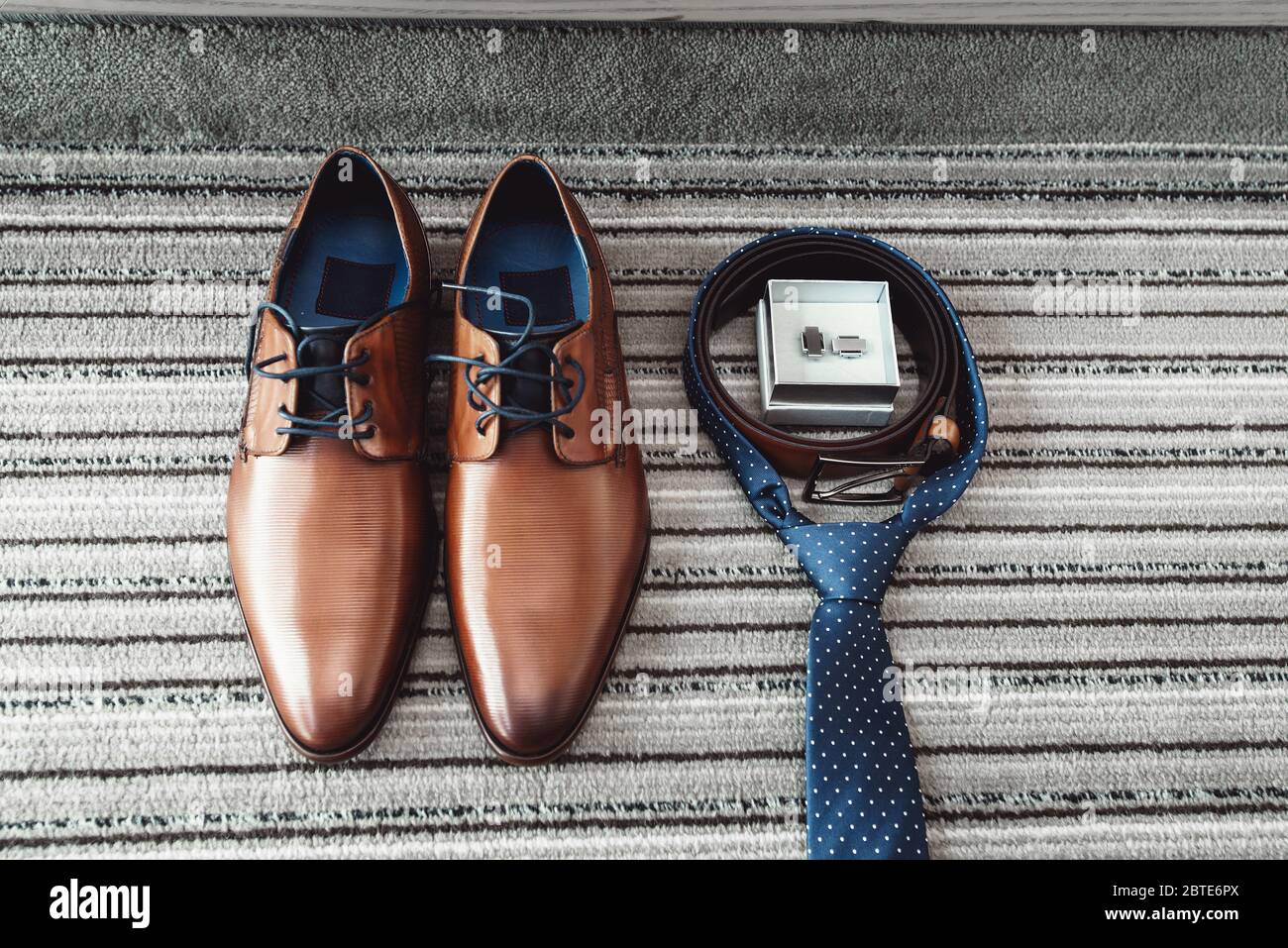 Braune Schuhe, blaue Krawatte, Gürtel und Manschettenknöpfe für den  Bräutigam Stockfotografie - Alamy