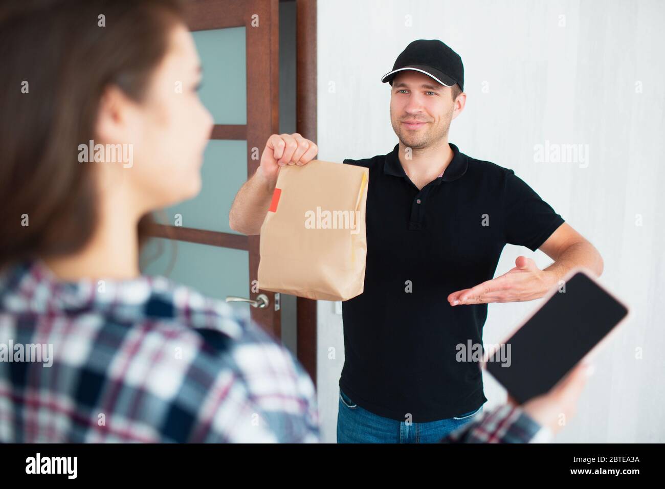 Konzept für die Lieferung von Lebensmitteln. Food Delivery Mann Brachte Essen Nach Hause Zu