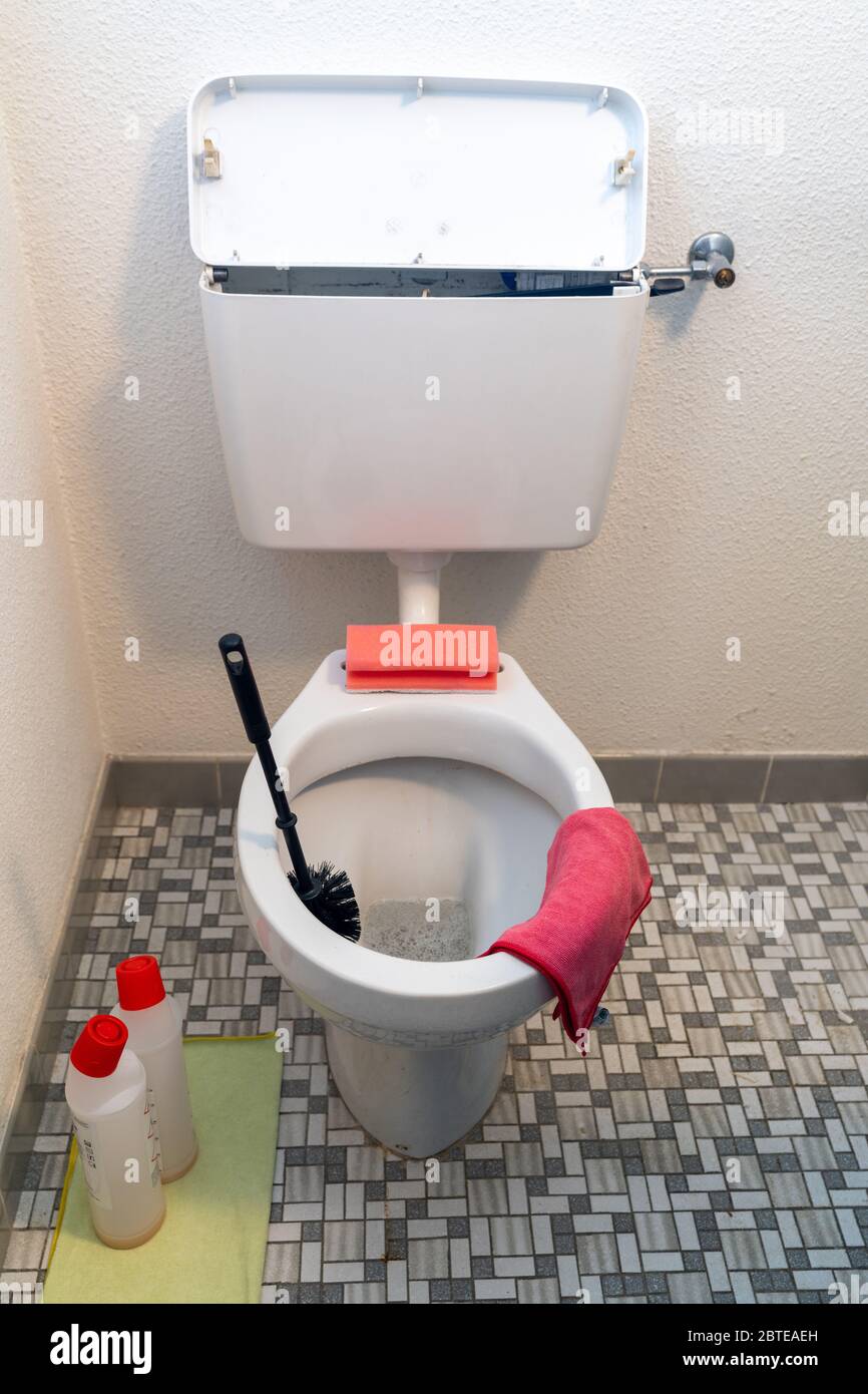 Eine vertikale Ansicht eines einfachen alten gefliesten Bad und WC mit verschiedenen Reinigungsmitteln Stockfoto