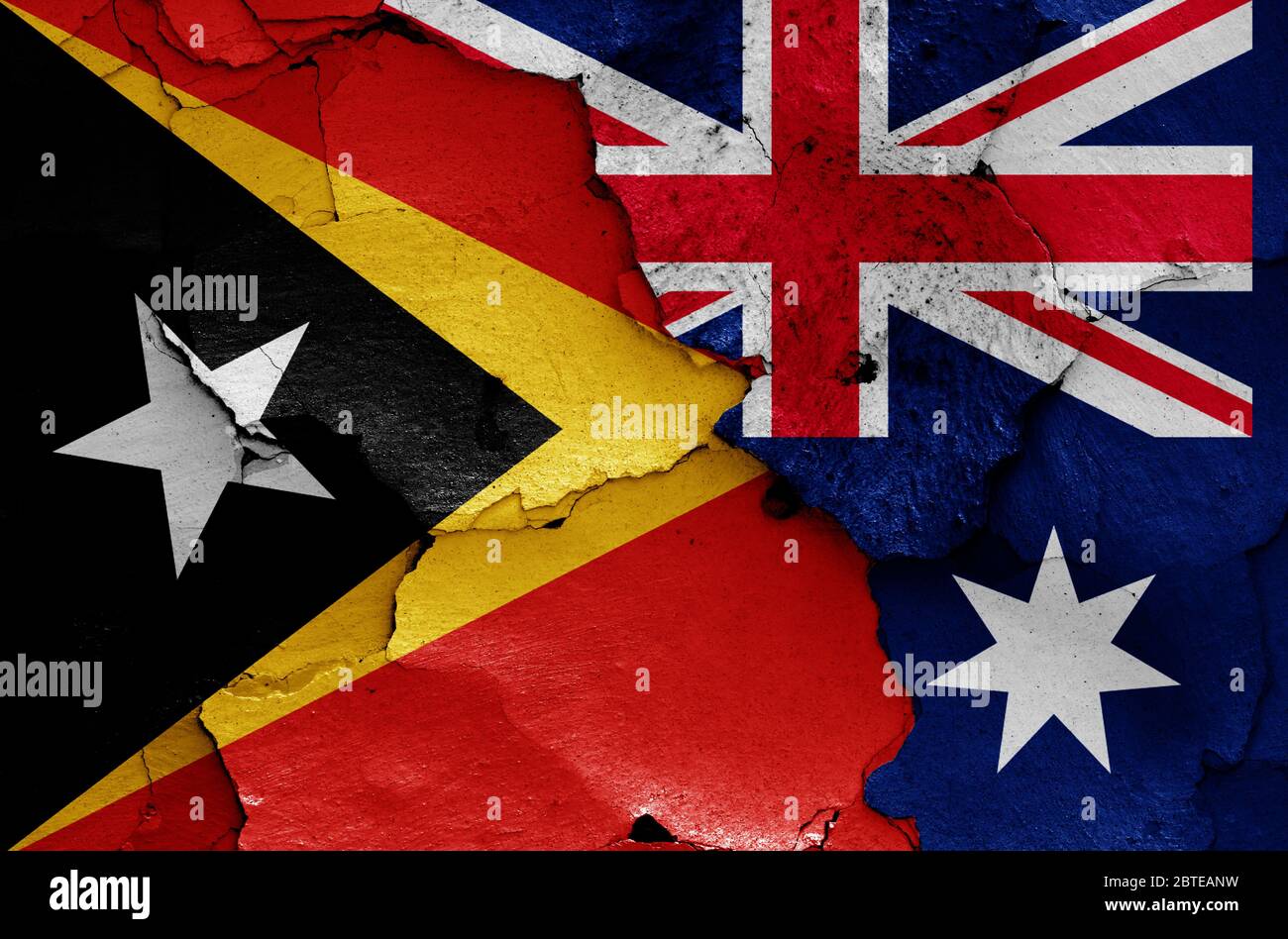 Flaggen von Osttimor und Australien auf rissige Wand gemalt Stockfoto