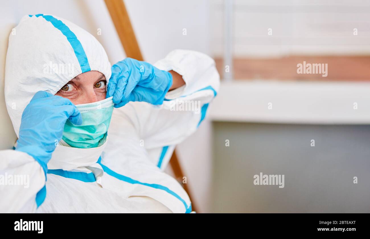 Krankenschwester oder Arzt, die Schutzkleidung trägt, zieht während der Covid-19-Epidemie eine neue Gesichtsmaske an Stockfoto
