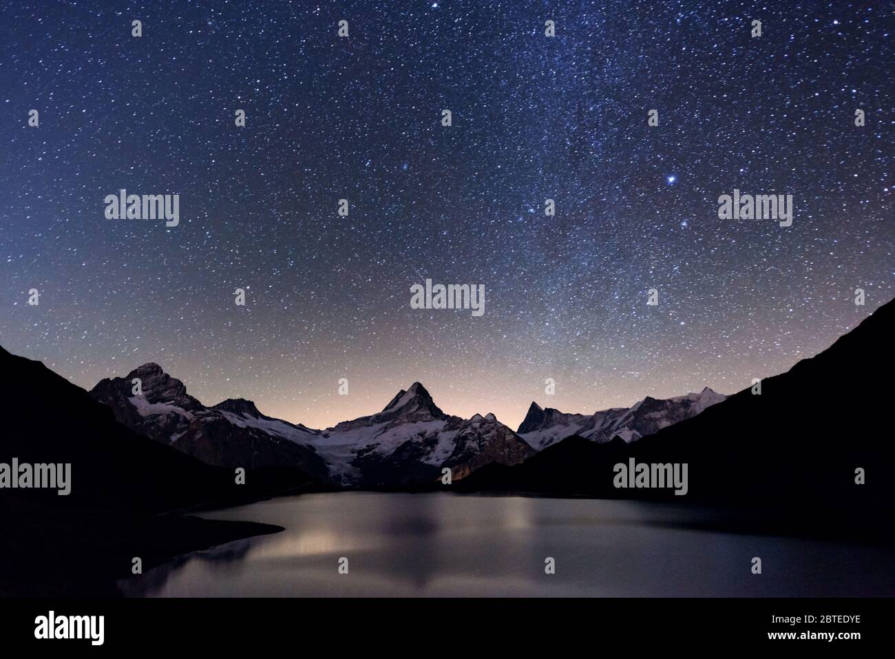 Unglaubliche nacht Bachalpsee See in den Schweizer Alpen. Schneebedeckten Gipfel des Wetterhorns Rosenhorn, Mittelhorn und für den Hintergrund. Tal von Grindelwald, Schweiz. Landschaft Astrofotografie Stockfoto