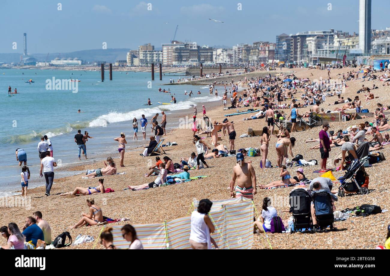Brighton UK 25. Mai 2020 - Besucher genießen den Feiertagshitzigen Sonnenschein am Brighton Strand heute, da die Temperaturen während der Coronavirus COVID-19 Pandemie-Krise die hohen 20er Jahre im Südosten Englands erreichen werden. Quelle: Simon Dack / Alamy Live News Stockfoto