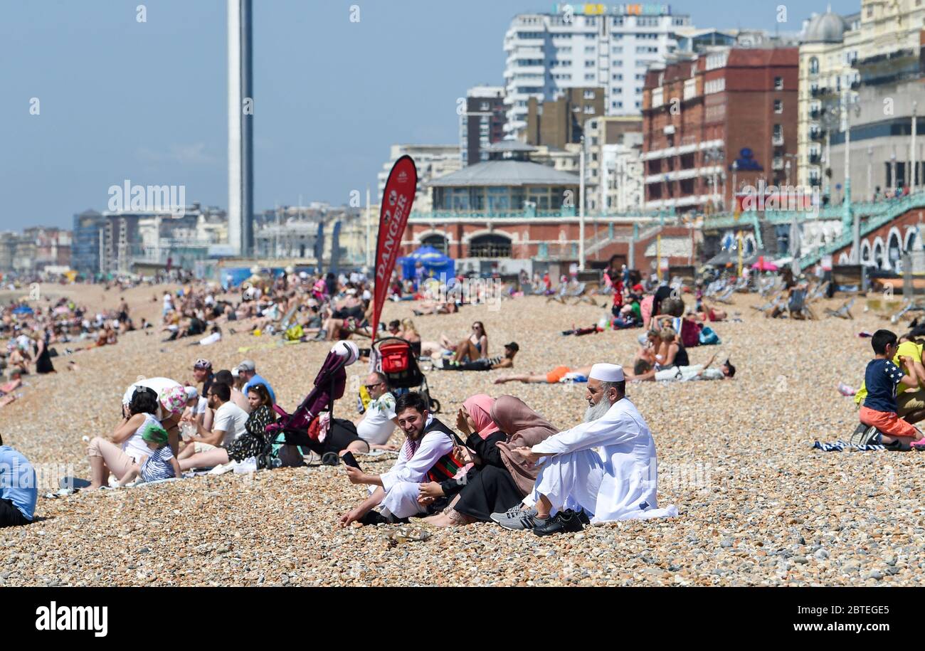 Brighton UK 25. Mai 2020 - Besucher genießen den Feiertagshitzigen Sonnenschein am Brighton Strand heute, da die Temperaturen während der Coronavirus COVID-19 Pandemie-Krise die hohen 20er Jahre im Südosten Englands erreichen werden. Quelle: Simon Dack / Alamy Live News Stockfoto