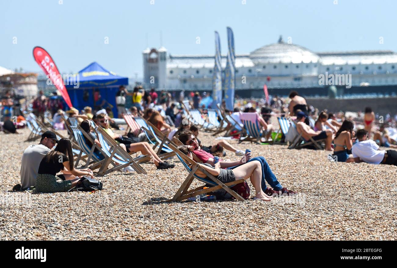 Brighton UK 25. Mai 2020 - Besucher genießen den Feiertagshitzigen Sonnenschein am Brighton Strand heute, da die Temperaturen während der Coronavirus COVID-19 Pandemie-Krise die hohen 20er Jahre im Südosten Englands erreichen werden. Quelle: Simon Dack / Alamy Live News Stockfoto