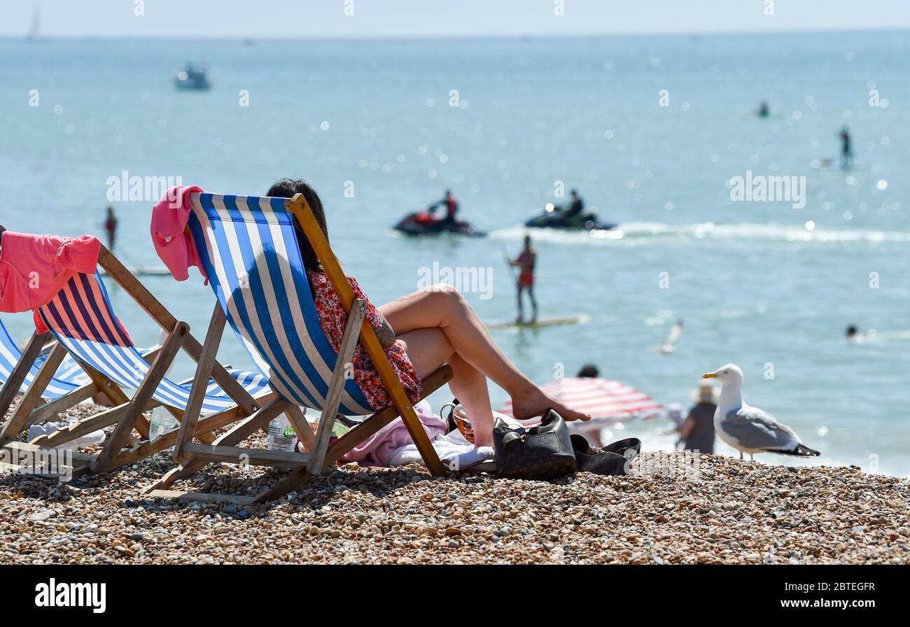 Brighton UK 25. Mai 2020 - Besucher genießen den Feiertagshitzigen Sonnenschein am Brighton Strand heute, da die Temperaturen während der Coronavirus COVID-19 Pandemie-Krise die hohen 20er Jahre im Südosten Englands erreichen werden. Quelle: Simon Dack / Alamy Live News Stockfoto