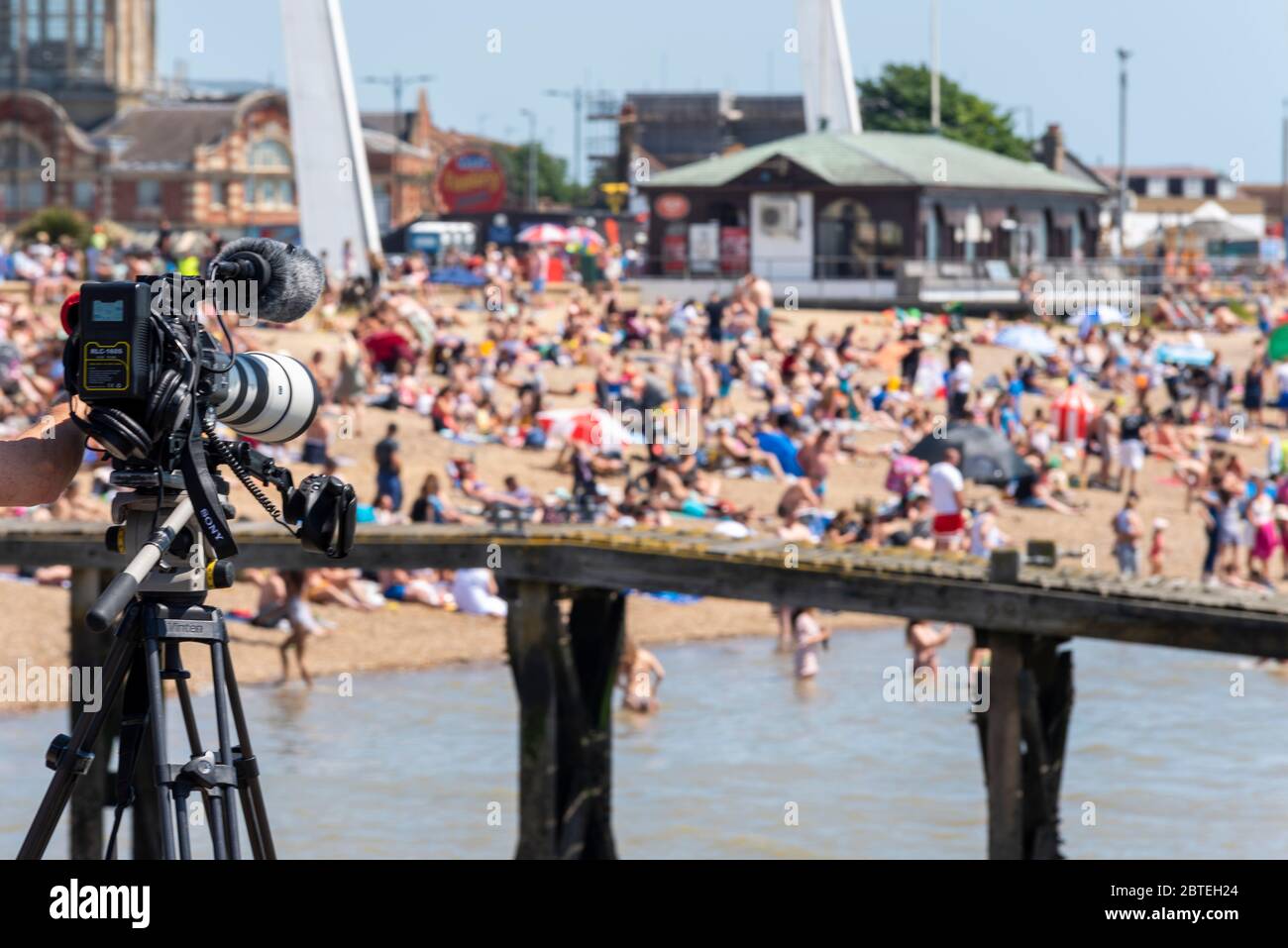 Southend on Sea, Essex, Großbritannien. 25. Mai 2020. Mit der Lockerung der britischen Lockdown-Richtlinien für die COVID-19 Coronavirus-Pandemie haben viele Menschen in die beliebte Küstenstadt für die Festtage, packen die Strände und gehen ins Meer. Es zog viel Medien, tv und Presse Berichterstattung. Fernsehkamera filmt den Strand und Menschen Stockfoto