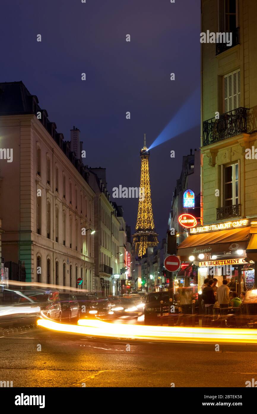 Paris, Frankreich - Nachtleben in Pariser Cafés mit dem Eiffelturm im Hintergrund. Stockfoto