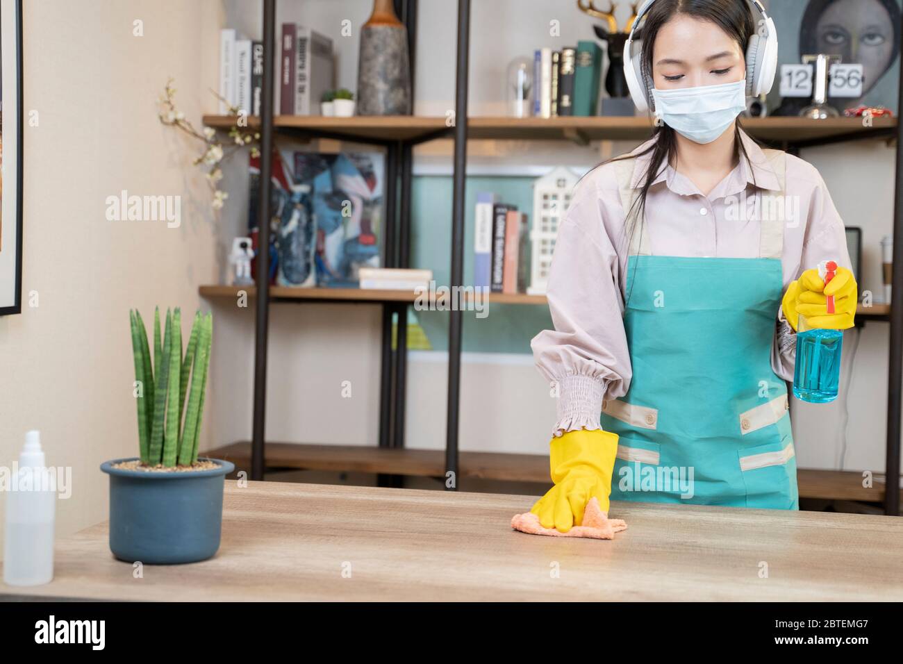 Eine Asiatische Junge Frau Reinigung Holztisch Zu Hause. Stockfoto