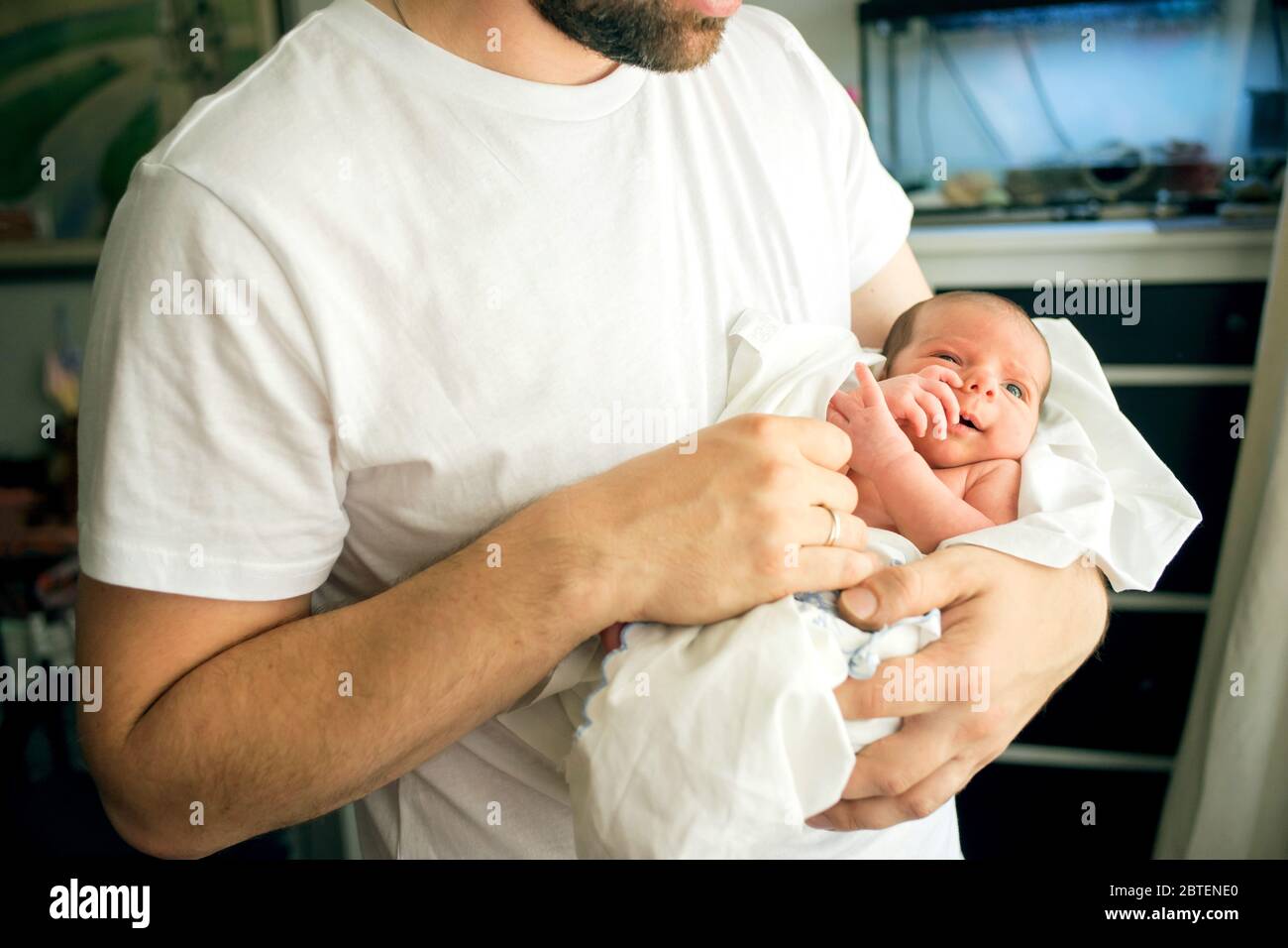 Vater hält nackt neugeborenen Sohn in seine Hände in einem weißen Windel Stockfoto