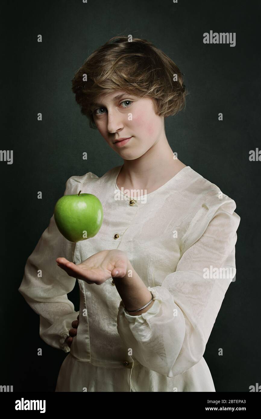 Levitation eines grünen Apfels . Surreales Porträt der jungen Frau Stockfoto