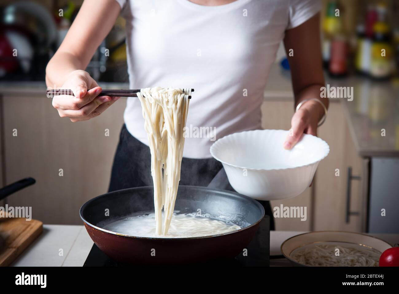 Frau, die Nudeln in der Küche kocht. Zubereitung von Speisen zu Hause Stockfoto