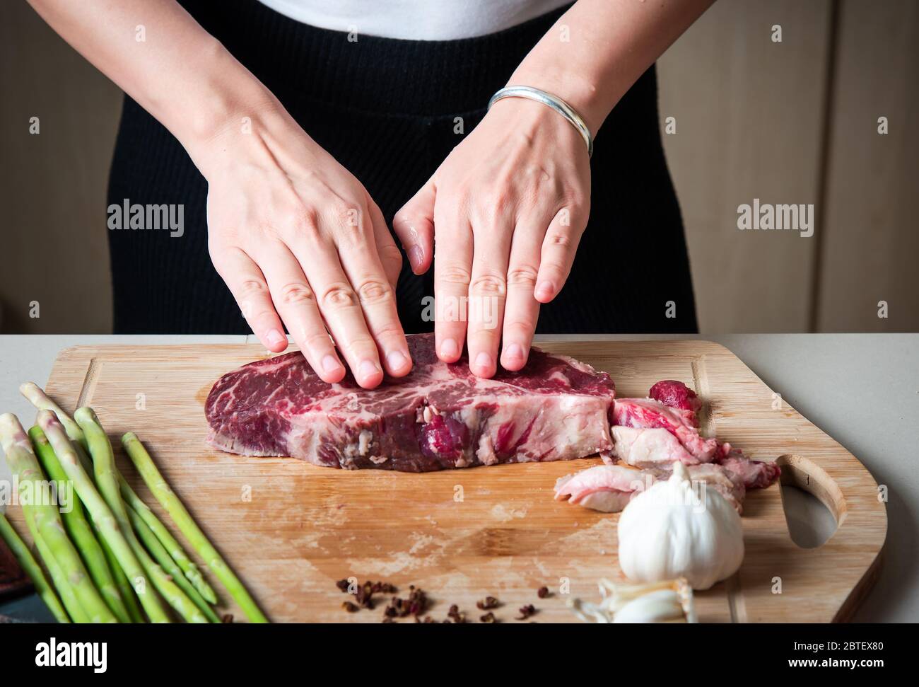 Frau bereitet Wagyu japanisches Rindfleisch Steak in der Küche. Hausmannskost und Zubereitung von Speisen Stockfoto