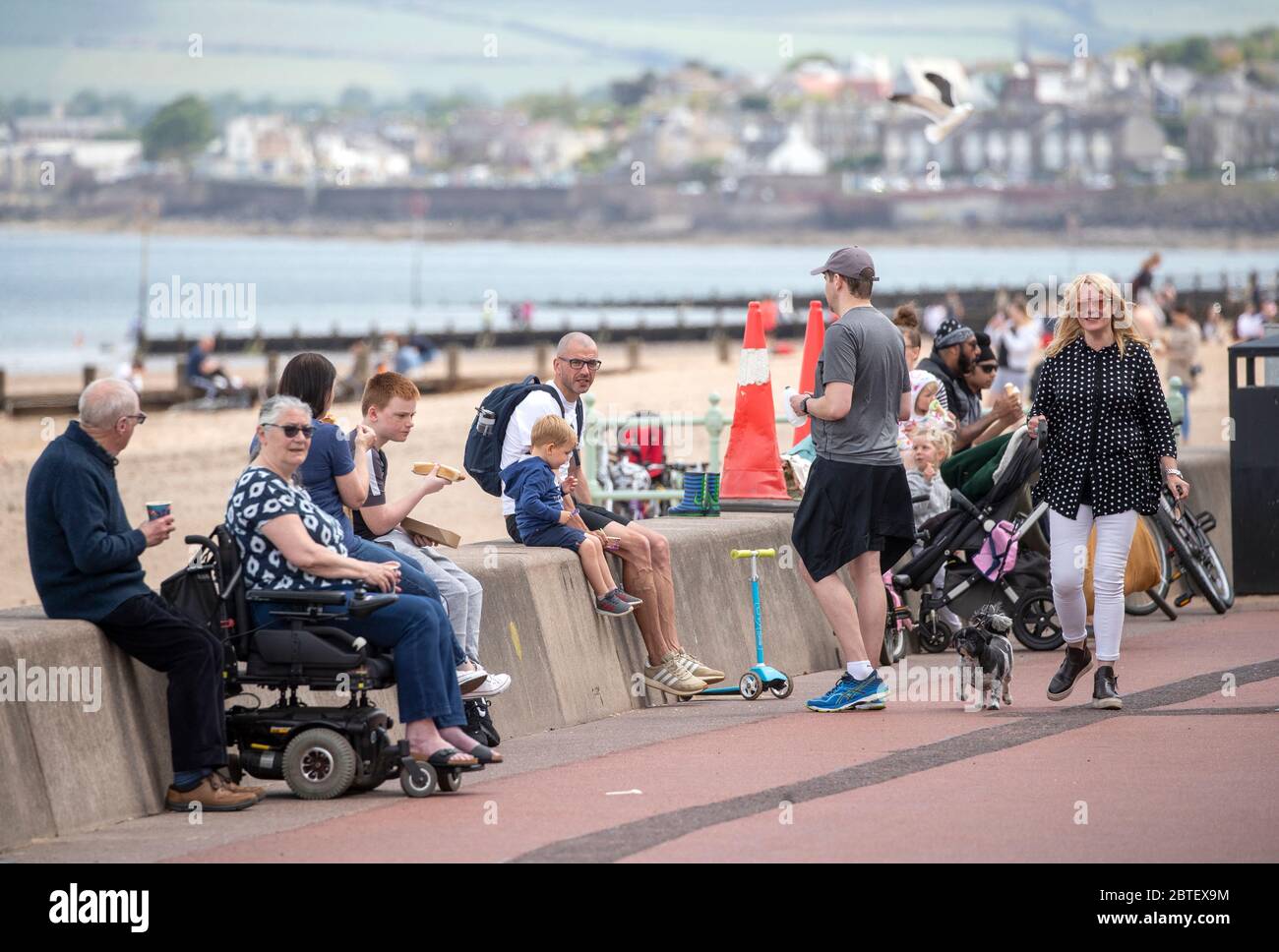 Die Menschen genießen das warme Wetter auf der Portobello Beach Promenade in Edinburgh, während die Menschen in Parks und Stränden mit Lockdown Maßnahmen erleichtert. Stockfoto