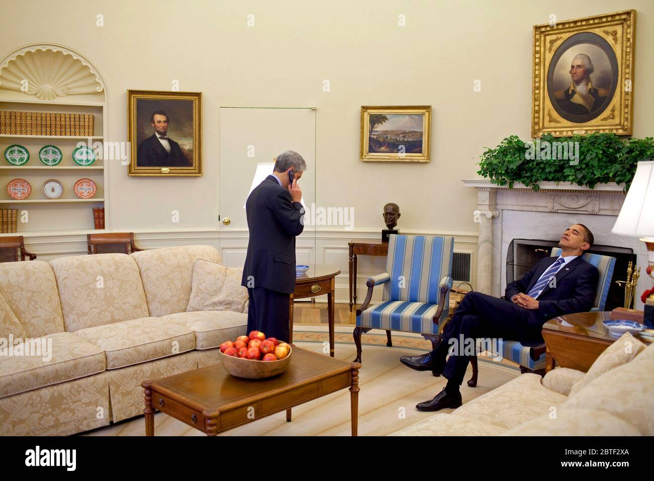 Präsident Barack Obama liegt mit dem Kopf auf seinem Stuhl, während Stabschef Rahm Emanuel Gespräche am Mobiltelefon im Oval Office 2/11/09. Stockfoto