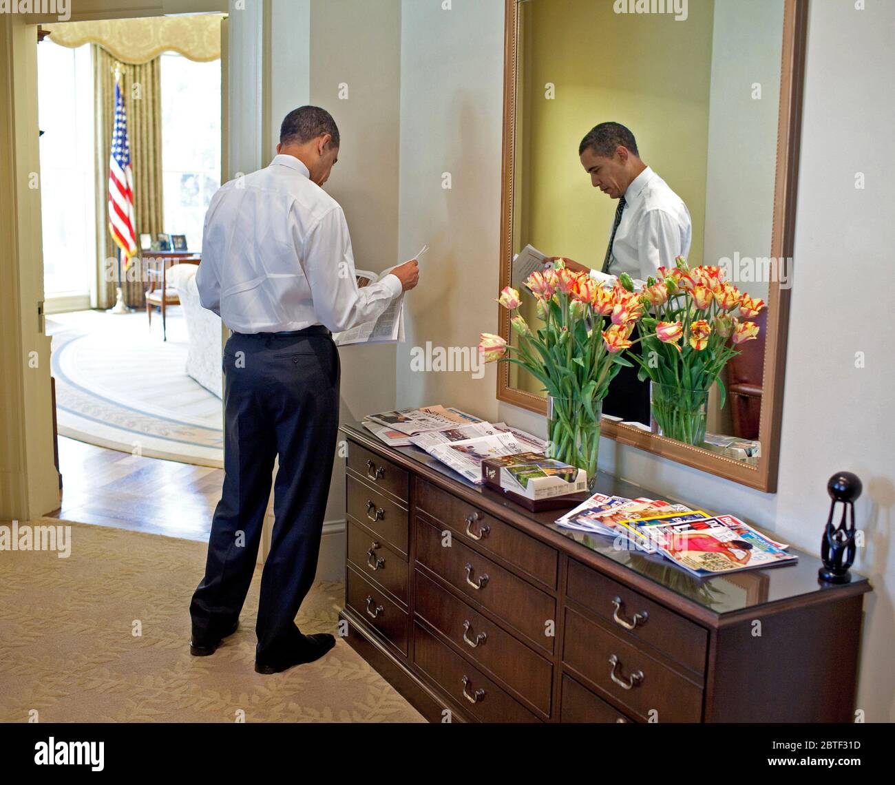 Präsident Barack Obama liest die Zeitung in der äußeren Oval Office 3/5/09. Stockfoto