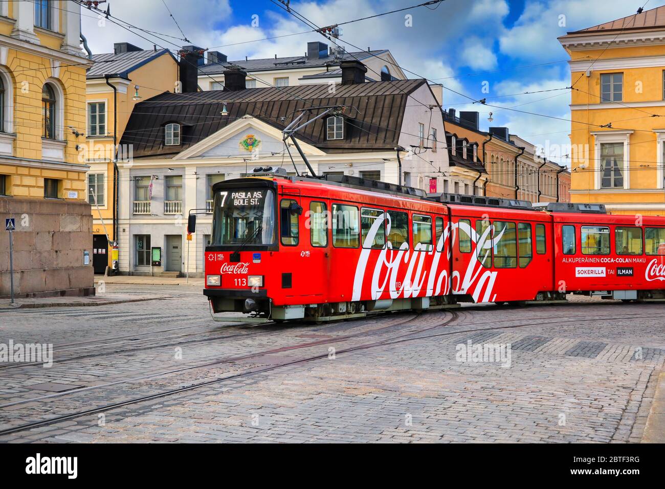 Umzug HSL Straßenbahn mit Coca-Cola Werbung und Sederholm House, das älteste Gebäude in der Innenstadt, im Hintergrund. Helsinki, Finnland. 25.Mai 2020. Stockfoto