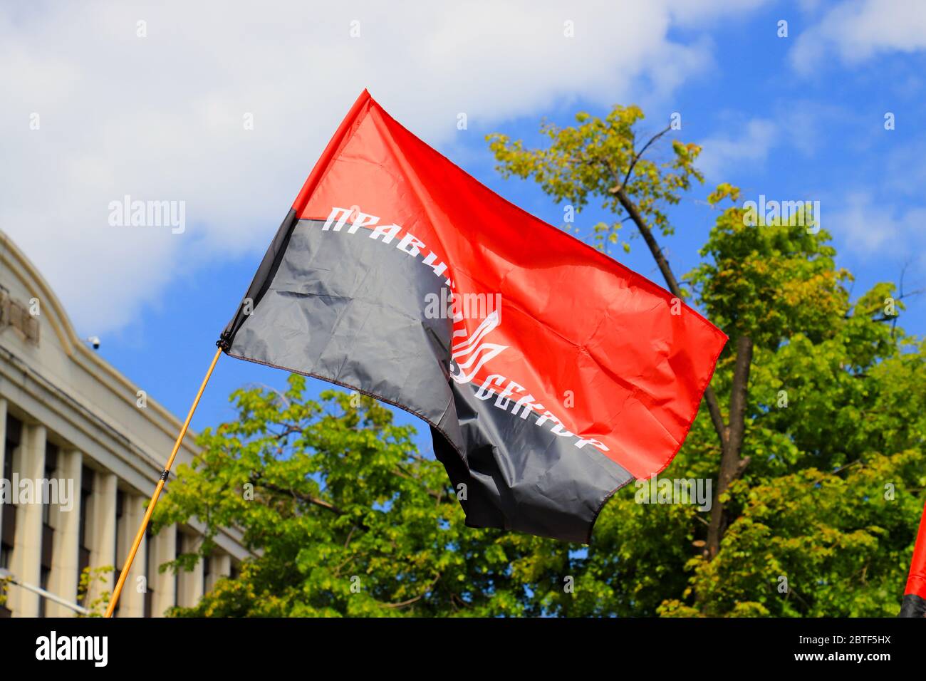Rot schwarz patriotische ukrainische Flagge mit der Inschrift in Ukrainisch - rechten Sektor und Wappen der Ukraine winken. Nationales Symbol, Flagge Stockfoto