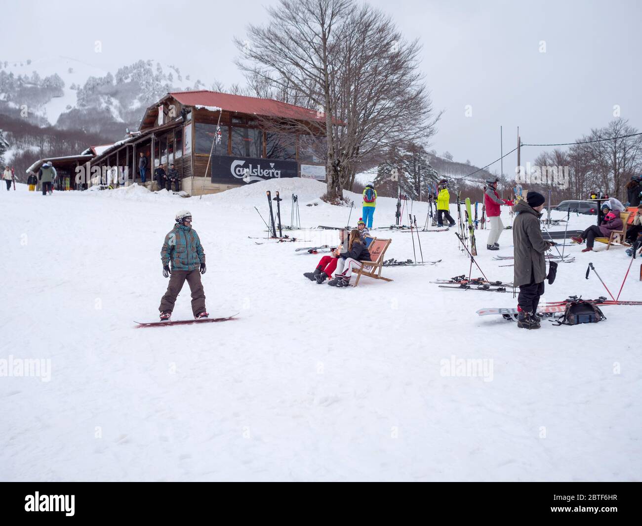 GREVENA, GRIECHENLAND - 24. MÄRZ 2018: Skigebiet Vasilitsa mit Schnee und Menschen auf der Piste bei bewölktem Wetter Stockfoto